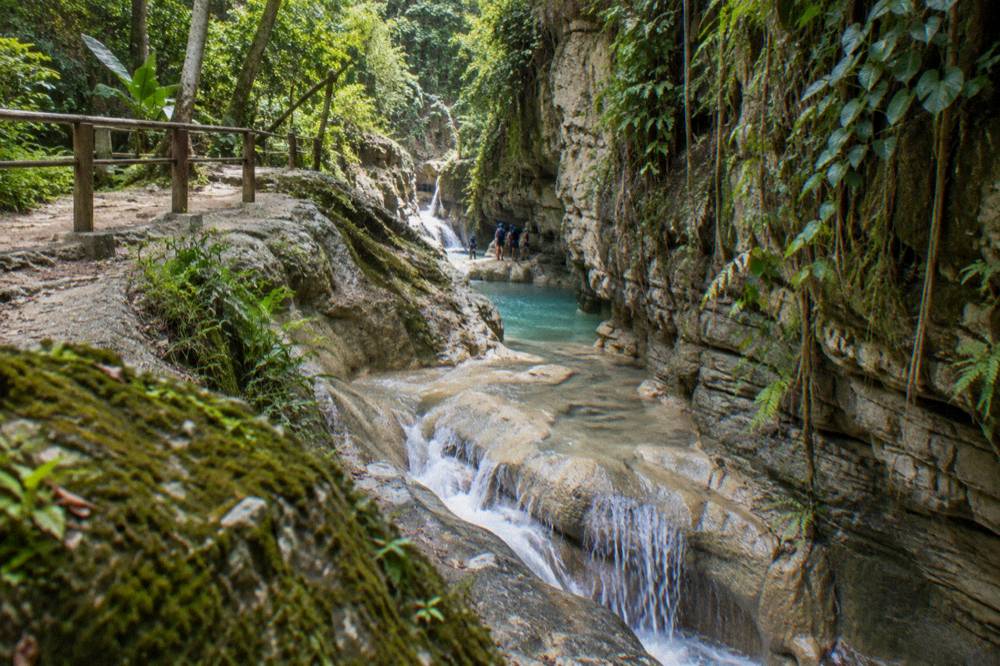 Waterfall pool surrounded by rock walls and tropical forest